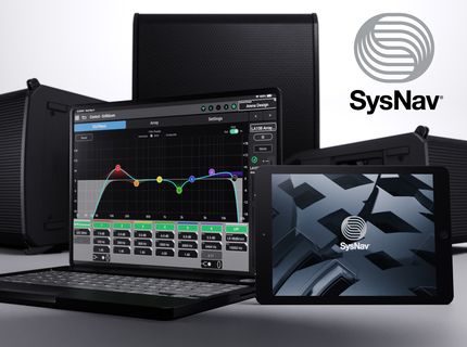 A laptop and tablet display the SysNav application with QSC speakers in the background